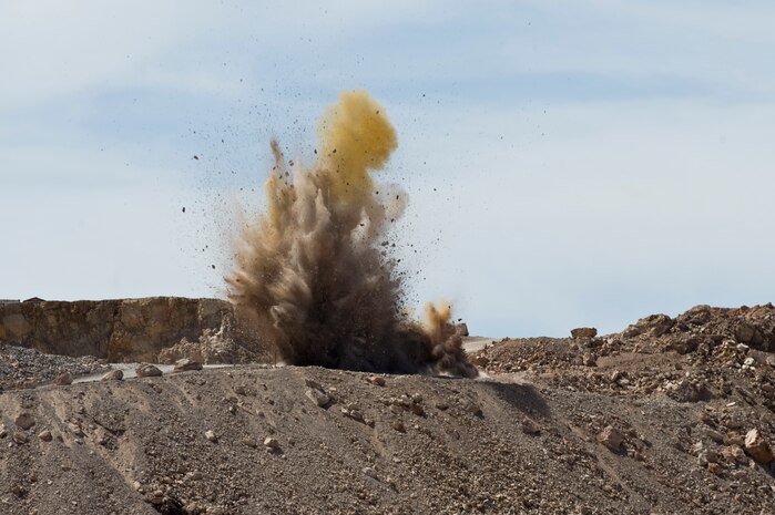 Rock is blasted off a mountain top at the 820th RED HORSE rock quarry March 28, 2013, at Nellis Air Force Base, Nev. A total of 250 tons of material were blasted from the site during this RED HORSE special capabilities class, which teaches basic introduction to explosives and quarry blasting. (U.S. Air Force photo by Airman 1st Class Christopher Tam)
  
