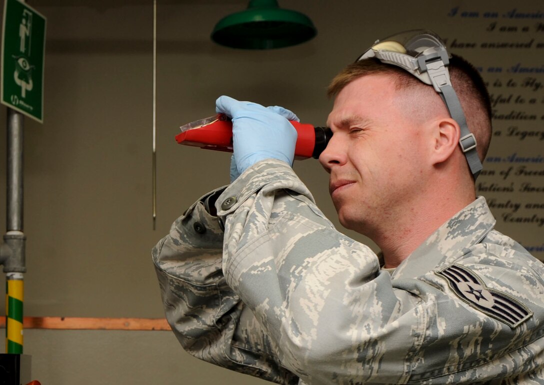 Staff Sgt. Dallas English, 28th Logistics Readiness Squadron fuels laboratory NCO in charge, looks into a refractometer during a test inside the fuels lab at Ellsworth Air Force Base, S.D, March 26, 2013. The refractometer is used to test icing inhibitor content levels in the fuel system, which lowers the freezing point of water and allows normal operations in cold temperatures. (U.S. Air Force photo by Airman 1st Class Anania Tekurio/Released)