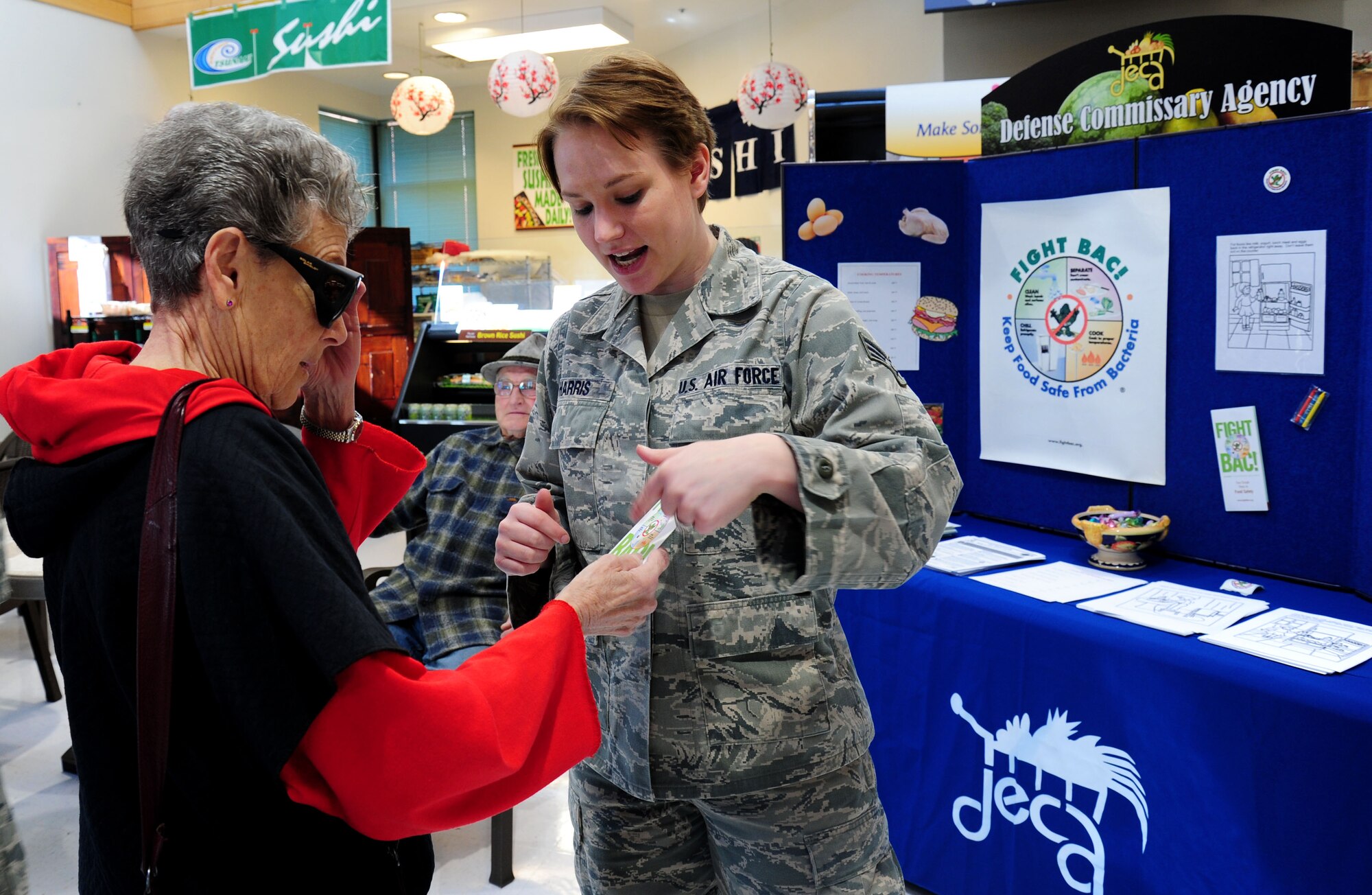 Senior Airman Jessica Harris, 92nd Aerospace Medicine Squadron public health technician, speaks with base residents on how to keep food safe from bacteria at Fairchild Air Force Base, Wash., April 2, 2013. Public Health hosts a food safety event every year to teach people about the importance of food safety highlighting cooking at the right temperature and washing your hands before and after cooking. (U.S. Air Force photo by Airman 1st Class Janelle Patiño)