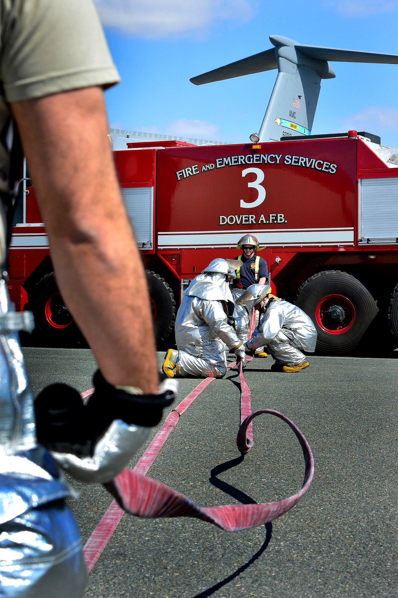 Firefighters with the 436th Civil Engineer Squadron fire department prepare a fire hose March 29, 2013, at Dover Air Force Base, Del. The fire department practiced emergency aircrew retrieval and firefighting. (U.S. Air Force photo/David Tucker)