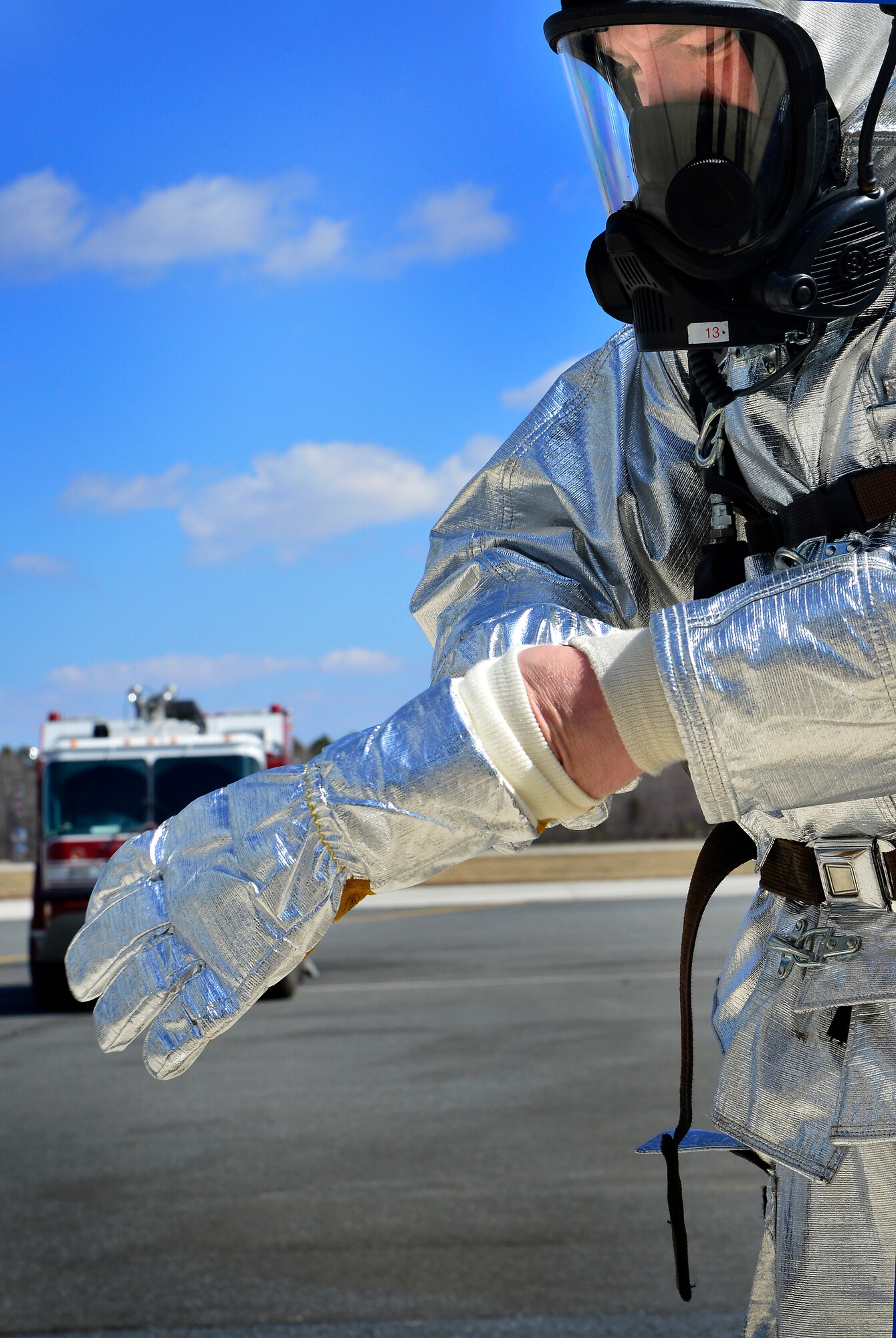 Airman Marc Green, 436th Civil Engineer Squadron fireman, puts on his protective gear March 29, 2013, at Dover Air Force Base, Del. Green and other members of the fire department practiced emergency aircrew retrieval techniques and firefighting. (U.S. Air Force photo/David Tucker)