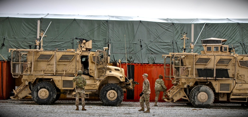 The 359th Inland Cargo Transfer Company Commander, U.S. Army Capt. Neil Stevenson, (center) walks in the 39 degree Fahrenheit drizzling rain to each truck, observing as the Soldiers conduct communications checks, mount their weapons and secure their gear in the miserable weather conditions at Bagram Air Field, Afghanistan Feb. 22, 2013. He bears the weight of ensuring he brings each soldier back home to their husbands, wives, parents, sons and daughters. (U.S. Army photo by Sgt. V. Michelle Woods/Released)
