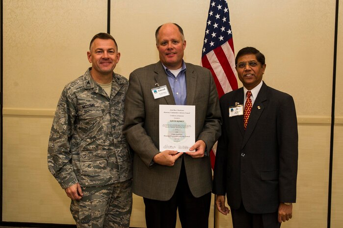 Col. Richard McComb (left), Joint Base Charleston commander, and Jay Patel (right), Advisory Council president, present former Honorary Commander David Ramey a certificate during the Honorary Commanders Induction Ceremony March 28, 2013, at Joint Base Charleston - Air Base, S.C. The Honorary Commanders program educates local community leaders about the various missions at JB Charleston. (U.S. Air Force photo/ Senior Airman George Goslin)