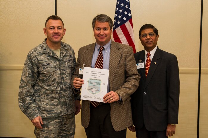 Col. Richard McComb (left), Joint Base Charleston commander, and Jay Patel (right), Advisory Council president, present former Honorary Commander Richard Moore a certificate for his service during the Honorary Commanders Induction Ceremony March 28, 2013, at Joint Base Charleston - Air Base, S.C. The Honorary Commanders program educates local community leaders about the various missions at JB Charleston. (U.S. Air Force photo/ Senior Airman George Goslin)