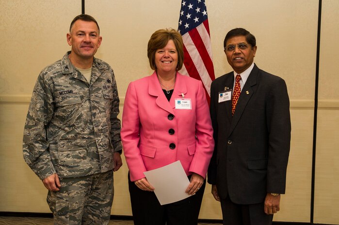 Col. Richard McComb (left), Joint Base Charleston commander, and Jay Patel (right), Advisory Council president present former Honorary Commander  Lisa Mitchell a certificate for her service during the Honorary Commanders Induction Ceremony March 28, 2013, at Joint Base Charleston - Air Base, S.C. The Honorary Commanders program educates local community leaders about the various missions at JB Charleston. (U.S. Air Force photo/ Senior Airman George Goslin)