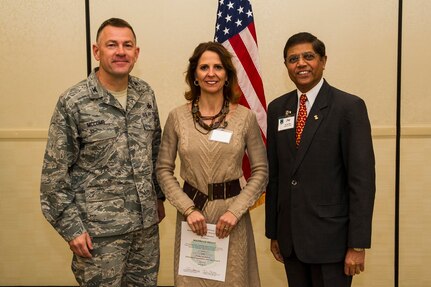 Col. Richard McComb (left), Joint Base Charleston commander, and Jay Patel (right), Advisory Council president, present former Honorary Commander Michelle Kelly a certificate for her service during the Honorary Commanders Induction Ceremony March 28, 2013, at Joint Base Charleston - Air Base, S.C. The Honorary Commanders program educates local community leaders about the various missions at JB Charleston. (U.S. Air Force photo/ Senior Airman George Goslin)