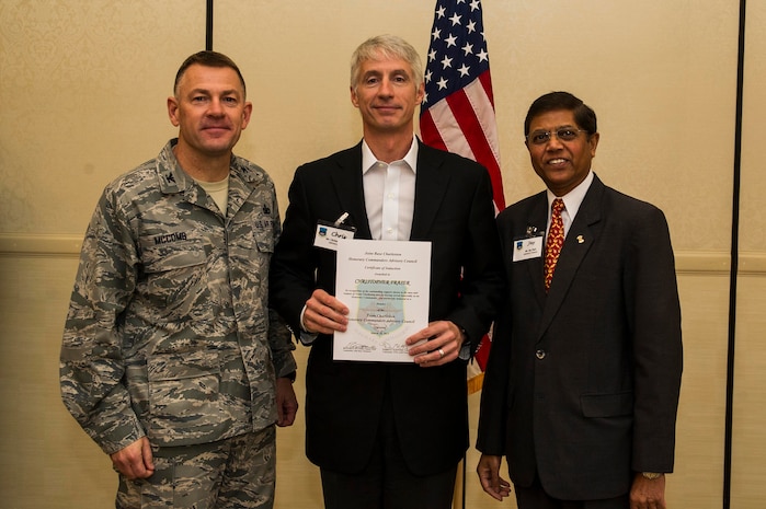 Col. Richard McComb (left), Joint Base Charleston commander, and Jay Patel (right), Advisory Council president, present former Honorary Commander Chris Fraser a certificate for his service during the Honorary Commanders Induction Ceremony March 28, 2013, at Joint Base Charleston - Air Base, S.C. The Honorary Commanders program educates local community leaders about the various missions at JB Charleston. (U.S. Air Force photo/ Senior Airman George Goslin)