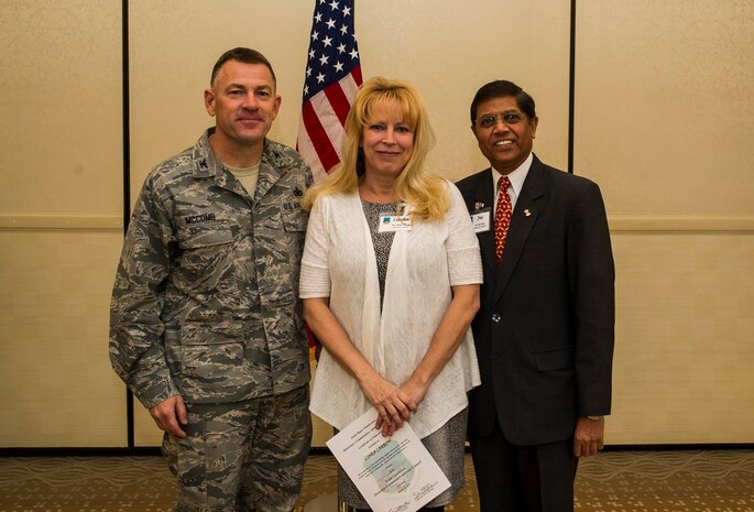 Col. Richard McComb (left), Joint Base Charleston commander, and Jay Patel (right), Advisory Council president, present former Honorary Commander Linda Carrow a certificate for her service during the Honorary Commanders Induction Ceremony March 28, 2013, at Joint Base Charleston - Air Base, S.C. The Honorary Commanders program educates local community leaders about the various missions at JB Charleston. (U.S. Air Force photo/ Senior Airman George Goslin)