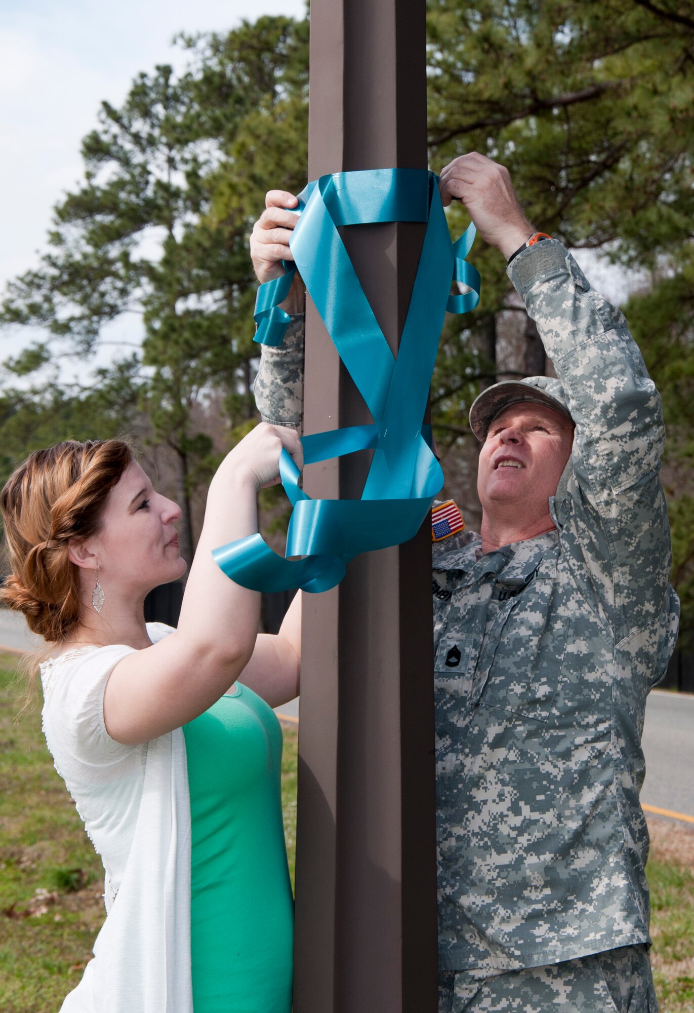From left, Megan Alpert, 733rd Mission Support Group installation sexual assault victim advocate, and U.S.Army Sgt. 1st Class Mark Ashby, 128th Aviation Brigade sexual assault response coordinator, hang ribbons to show support of Sexual Assault Awareness Month at Fort Eustis Va., April 1, 2013. The month of April is designated as Sexual Assault Awareness Month in the United States; the goal is to raise public awareness about sexual violence and to educate communities and individuals on how to prevent sexual violence. (U.S. Air Force photo by Tech. Sgt. April Wickes/Released)