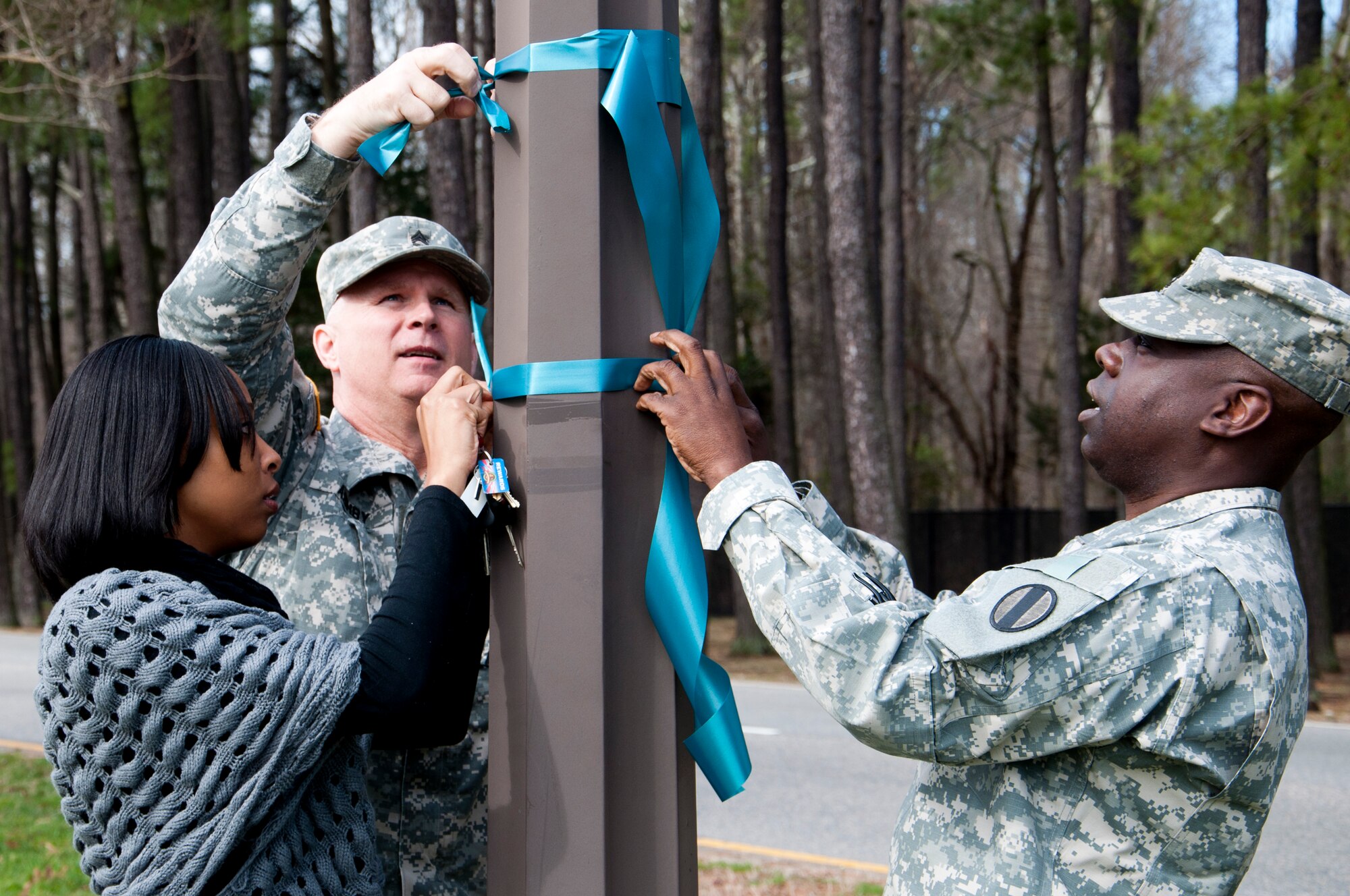 From left, LaToya Wilson, 93rd Signal Brigade sexual assault victim advocate, U.S. Army Sgt. 1st Class Mark Ashby, 128th Aviation Brigade sexual assault response coordinator, and Master Sgt. Kevin Parker, U.S. Army Training and Doctrine Command installation SARC, hang ribbons to show support of Sexual Assault Awareness Month at Fort Eustis Va., April 1, 2013. National Sexual Assault Awareness Month is an annual campaign to raise awareness and educate communities on the prevention of sexual violence. (U.S. Air Force photo by Tech. Sgt. April Wickes/Released)
