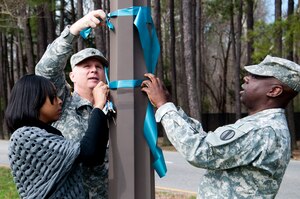 From left, LaToya Wilson, 93rd Signal Brigade sexual assault victim advocate, U.S. Army Sgt. 1st Class Mark Ashby, 128th Aviation Brigade sexual assault response coordinator, and Master Sgt. Kevin Parker, U.S. Army Training and Doctrine Command installation SARC, hang ribbons to show support of Sexual Assault Awareness Month at Fort Eustis Va., April 1, 2013. National Sexual Assault Awareness Month is an annual campaign to raise awareness and educate communities on the prevention of sexual violence. (U.S. Air Force photo by Tech. Sgt. April Wickes/Released)