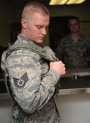 Staff Sgt. Travis Bledsoe, 509th Security Forces Squadron patrolman, tries on a new plate carrier as Tech. Sgt. Jeremy Sanford, 509th SFS NCOIC of supply, oversees, at Whiteman Air Force Base, Mo., March 20, 2013. Sanford issues 20 to 25 pieces of equipment to each new member that arrives to the squadron. (U.S. Air Force photo by Staff Sgt. Nick Wilson/Released)
