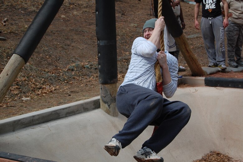 Airman 1st Class Karl Ahner, 21st Comptroller Squadron, swings across a pit during Wingman Day, at Jacks Valley training area at the Air Force Academy, March 28. Wingman Day is designed to highlight the four pillars of wellness: physical, mental, social and spiritual fitness. (U.S. Air Force photo by Col. William Marrs)