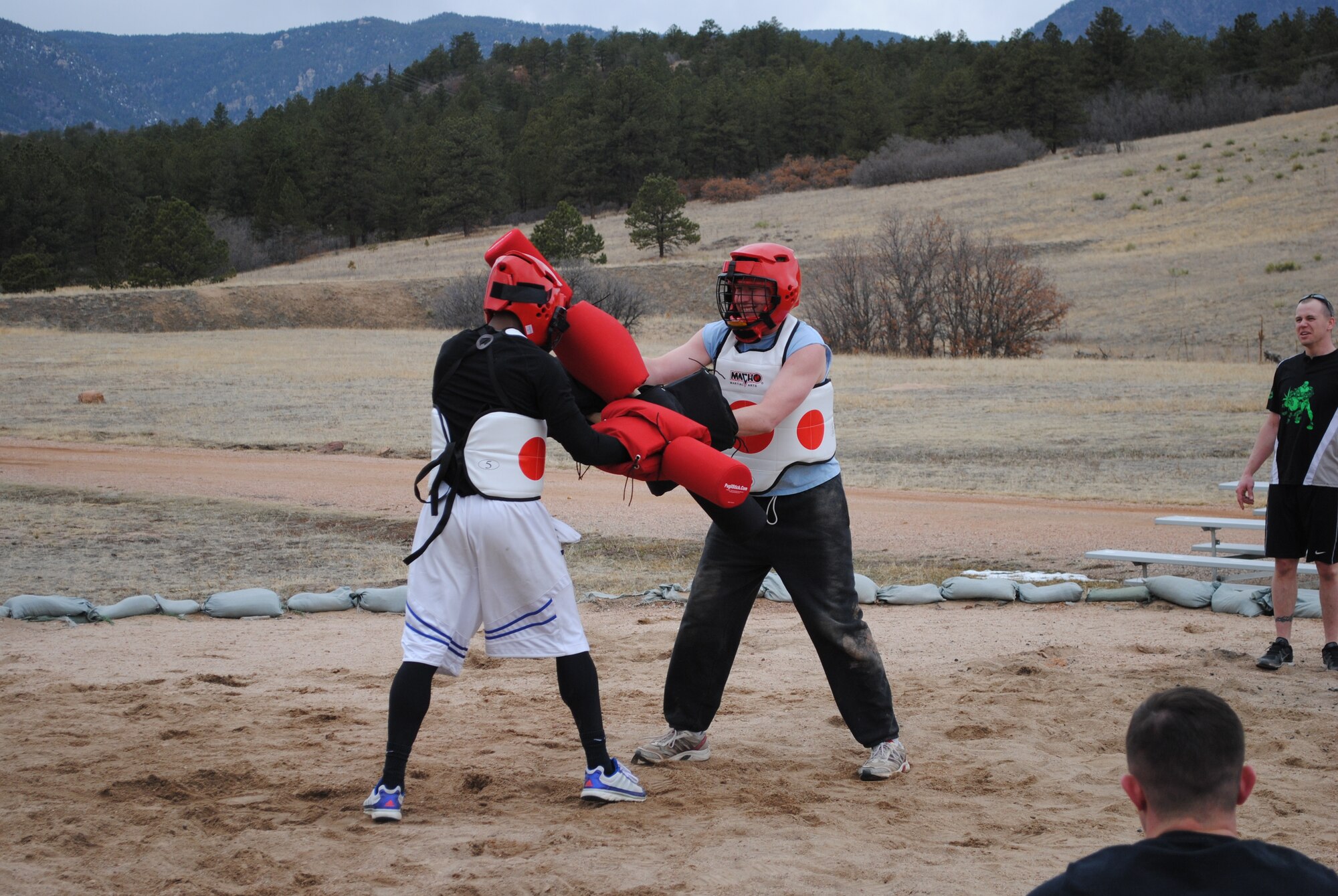 Senior Airman Mark Thompson (left) and Senior Airman Kevin Swope, members of the 21st Comptroller Squadron, battle each other using pugil sticks at Jacks Valley training area at the Air Force Academy, March 28. The battles were part of the 21st Space Wing’s biannual Wingman Day, which was designed to highlight the four pillars of wellness:  physical, mental, social and spiritual fitness. (U.S. Air Force photo by Staff Sgt. James Blaz)