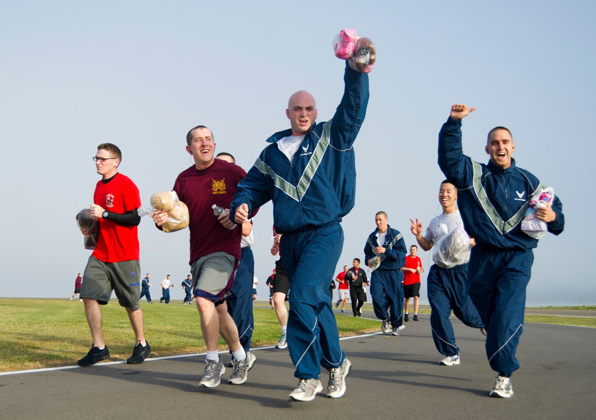 Runners in the 81st Training Group's Teddy Bear Run cheer as they come around the flightline on the final stretch of the run March 29, 2013, at Keesler Air Force Base, Miss. About 750 bears were donated for the run and will be passed on to children in crisis situations.  (U.S. Air Force photo by Adam Bond)