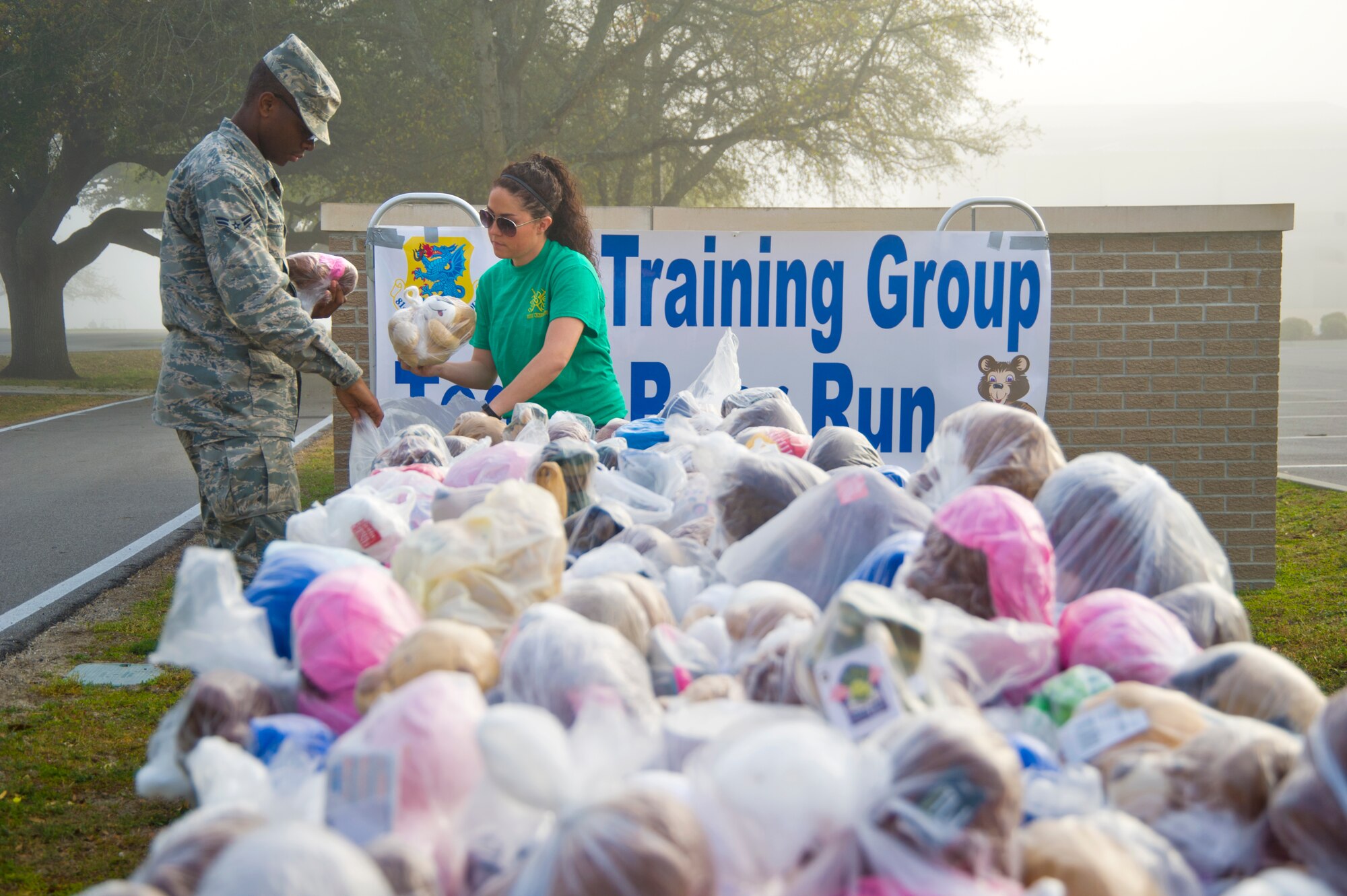 Airmen 1st Class DeAndre Price, 335th Training Squadron, and Samantha Gauthier, 338th Training Squadron, arrange teddy bears to be handed out to runners during a Teddy Bear Run March 29, 2013 at Keesler Air Force Base, Miss. About 750 bears were donated for the run and will be passed on to children in crisis situations.  (U.S. Air Force photo by Adam Bond)