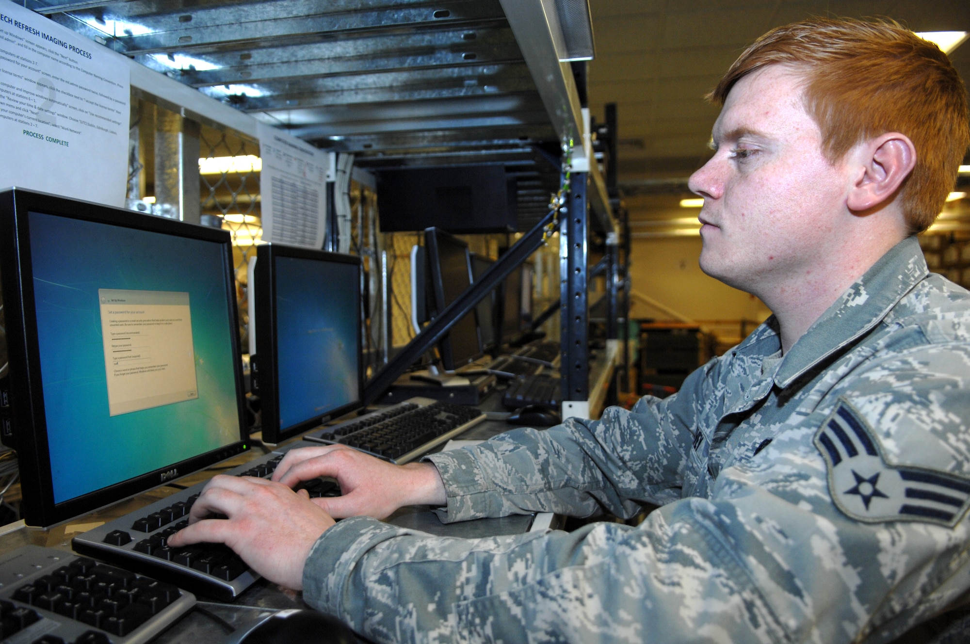 Senior Airman Kevin Davey, 100th Communications Squadron client systems technician from Jedburg S.C., finishes installing critical system software to a row of computers. (U.S. Air Force photo by Airman 1st Class Dillon Johnston/Released)