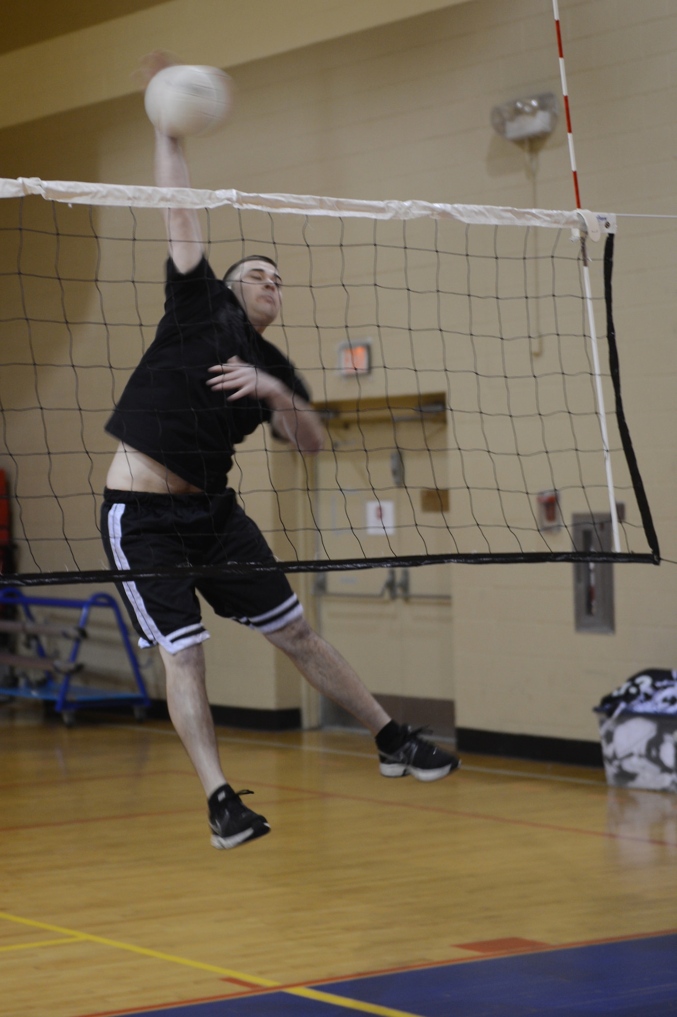Senior Airman Christopher O'Brath, 20th Component Maintenance Squadron electronic warfare technician, spikes a ball over the net during his warm-up before a volleyball game at Shaw Air Force Base, S.C., March 28, 2013. An intramural volleyball competition is being held at the fitness center until April 16. There is a game scheduled at 6:00, 6:45 and 7:30 p.m. every Monday, Tuesday, Wednesday and Thursday. (U.S. Air Force photo by Airman 1st Class Krystal M. Jeffers/Released)