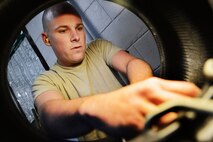U.S. Air Force Airman 1st Class Donald Lord, 20th Logistics Readiness Squadron vehicle maintainer, inflates a tire at Shaw Air Force Base, S.C., March 29, 2013. The vehicle management flight is responsible for overall maintenance of the wing's vehicle fleet and accountability of vehicle assets, ensuring their integrity for mission capability. (U.S. Air Force photo by Airman 1st Class Nicole Sikorski/Released)