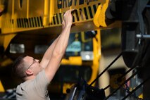 U.S. Air Force Airman 1st Class Caleb Farmer, 20th Logistics Readiness Squadron vehicle maintainer, puts safety markings on a crane at Shaw Air Force Base, S.C., March 29, 2013. The vehicle management flight is responsible for overall maintenance of the wing's vehicle fleet and accountability of vehicle assets, ensuring their integrity and mission capability. (U.S. Air Force photo by Airman 1st Class Nicole Sikorski/Released)