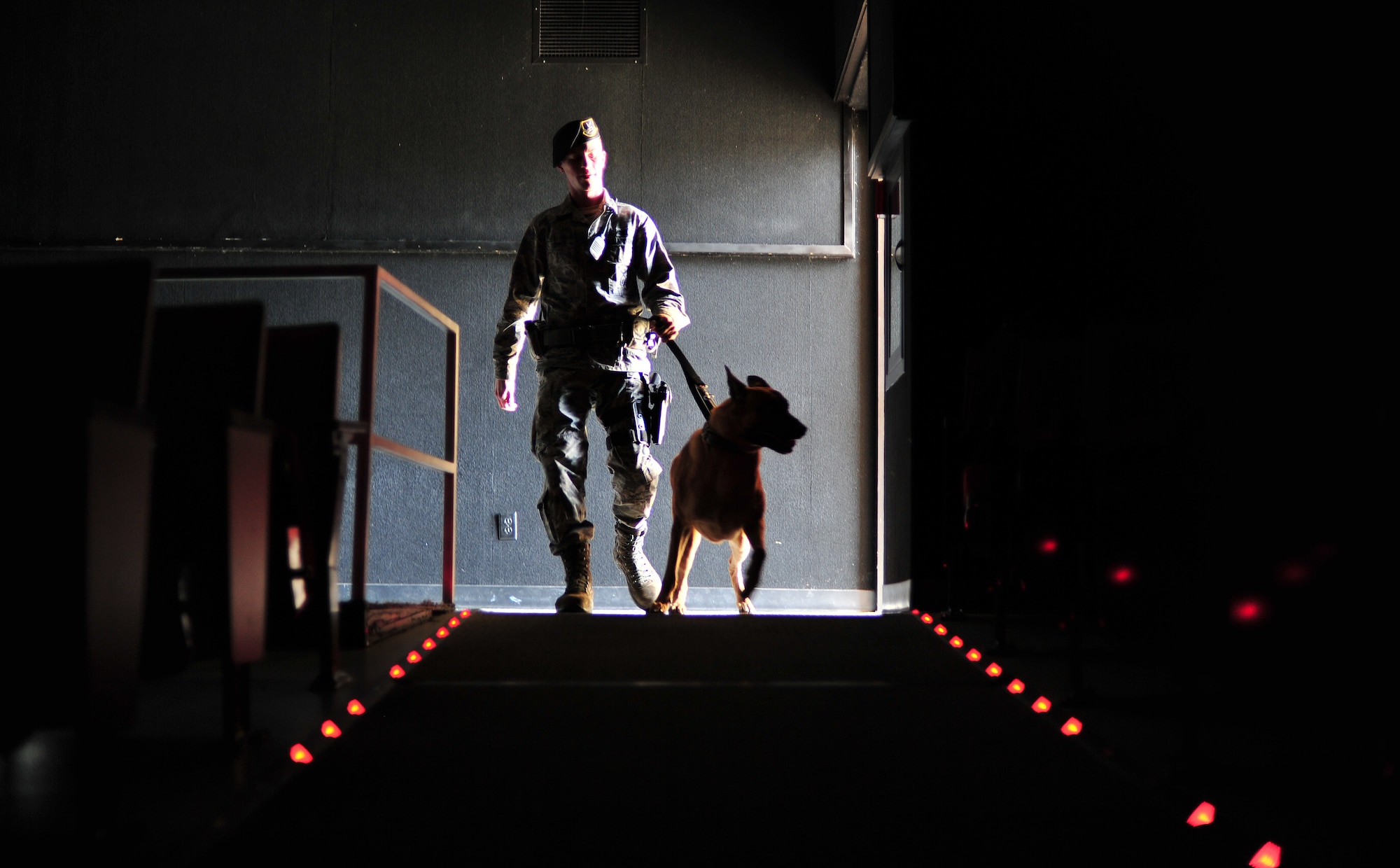 Staff Sgt. Justin Benfer searches the base theater with Uutah during a training exercise at Fairchild Air Force Base, Wash., March 21, 2013. The 92nd Security Forces Squadron is home to eight military working dogs. Benfer and Uutah are military working dog handler and K-9 assigned to the 92nd SFS. (U.S. Air Force photo by Senior Airman Taylor Curry)