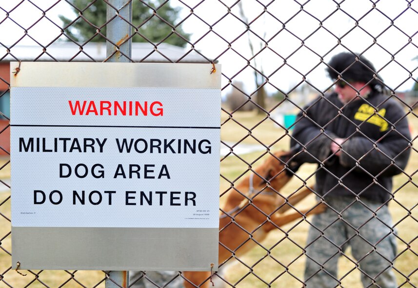 A warning sign is observed on the fence line of the military working dog area to inform people not to enter the area at Fairchild Air Force Base, Wash., March 20, 2013. Military working dog handlers train with their dogs inside the perimeter. (U.S. Air Force photo by Senior Airman Taylor Curry)