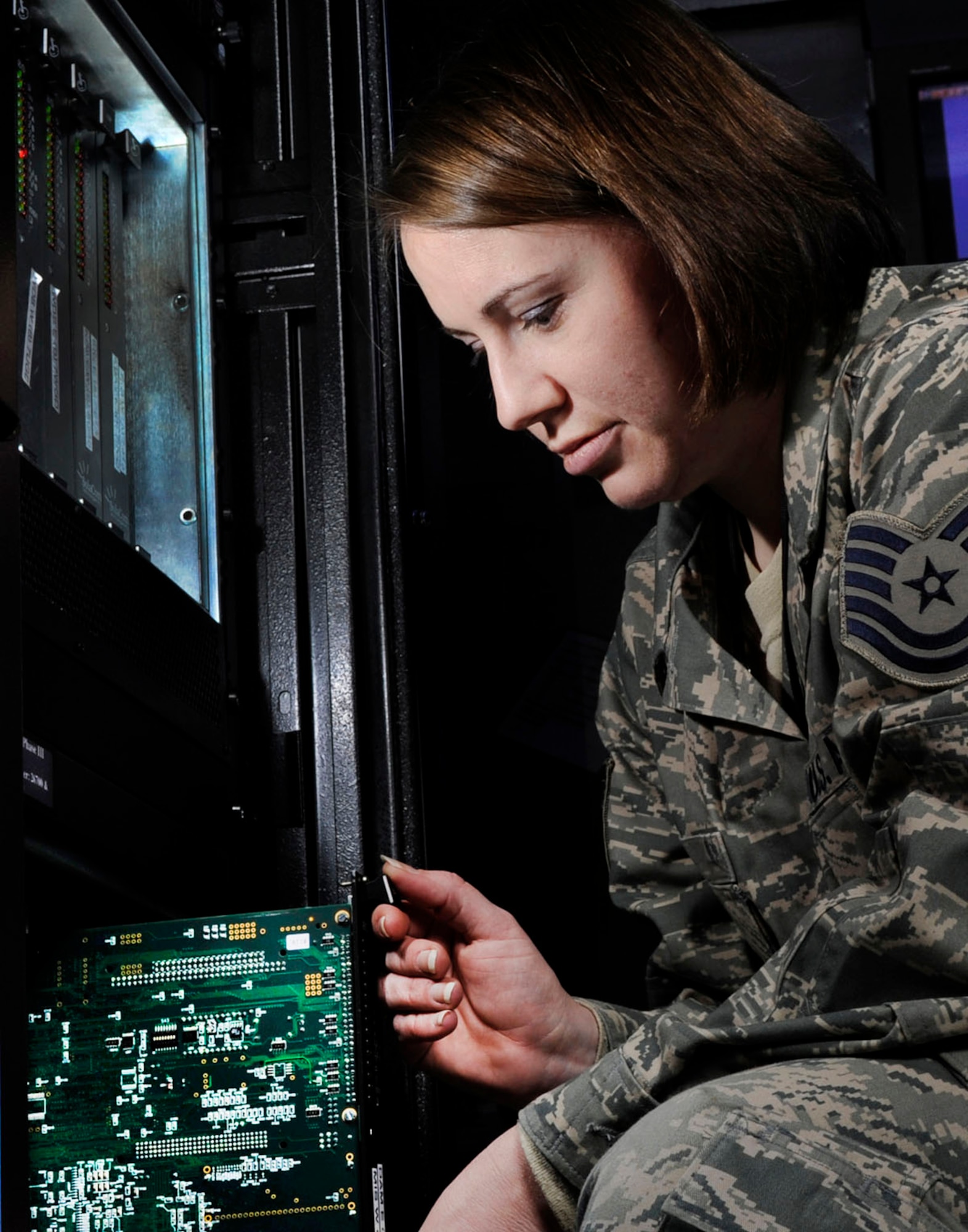 Tech. Sgt. Kimberly Derr swaps a communications processing module card on a switch at Joint Base Andrews, Md. Derr is a radio frequency transmissions system technician assigned to the 89th Communications Squadron/High Frequency Global Communications System section. (U.S. Air Force photo/Val Gempis)