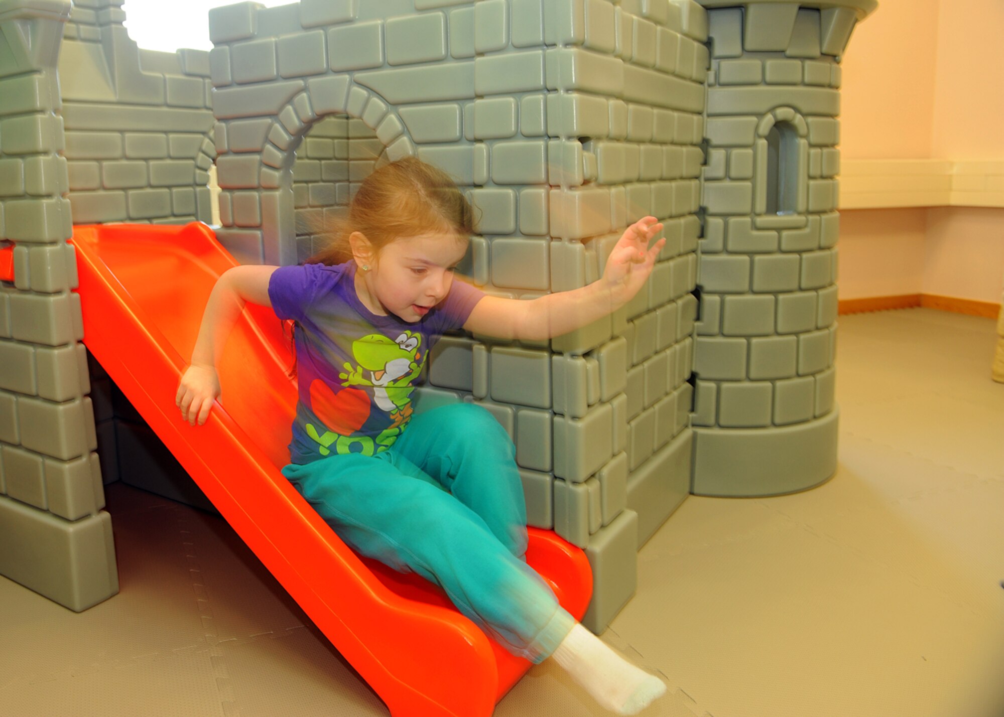 SPANGDAHLEM AIR BASE, Germany -- Allison Aiken, daughter of U.S. Air Force Master Sgt. Patrick Aiken, 52nd Component Maintenance Squadron, slides down from a children’s castle April 2, 2013, after the opening ceremony for Spangdahlem Air Base’s new child playroom. The 52nd Civil Engineer Squadron renovated the room, and the funds for the play items came from the Spangdahlem Spouses and Enlisted Members Club; Officers and Civilian Spouses Club; and the Bitburg Middle School Parent Teacher Student Association. (U.S. Air Force photo by Staff Sgt. Daryl Knee/Released)