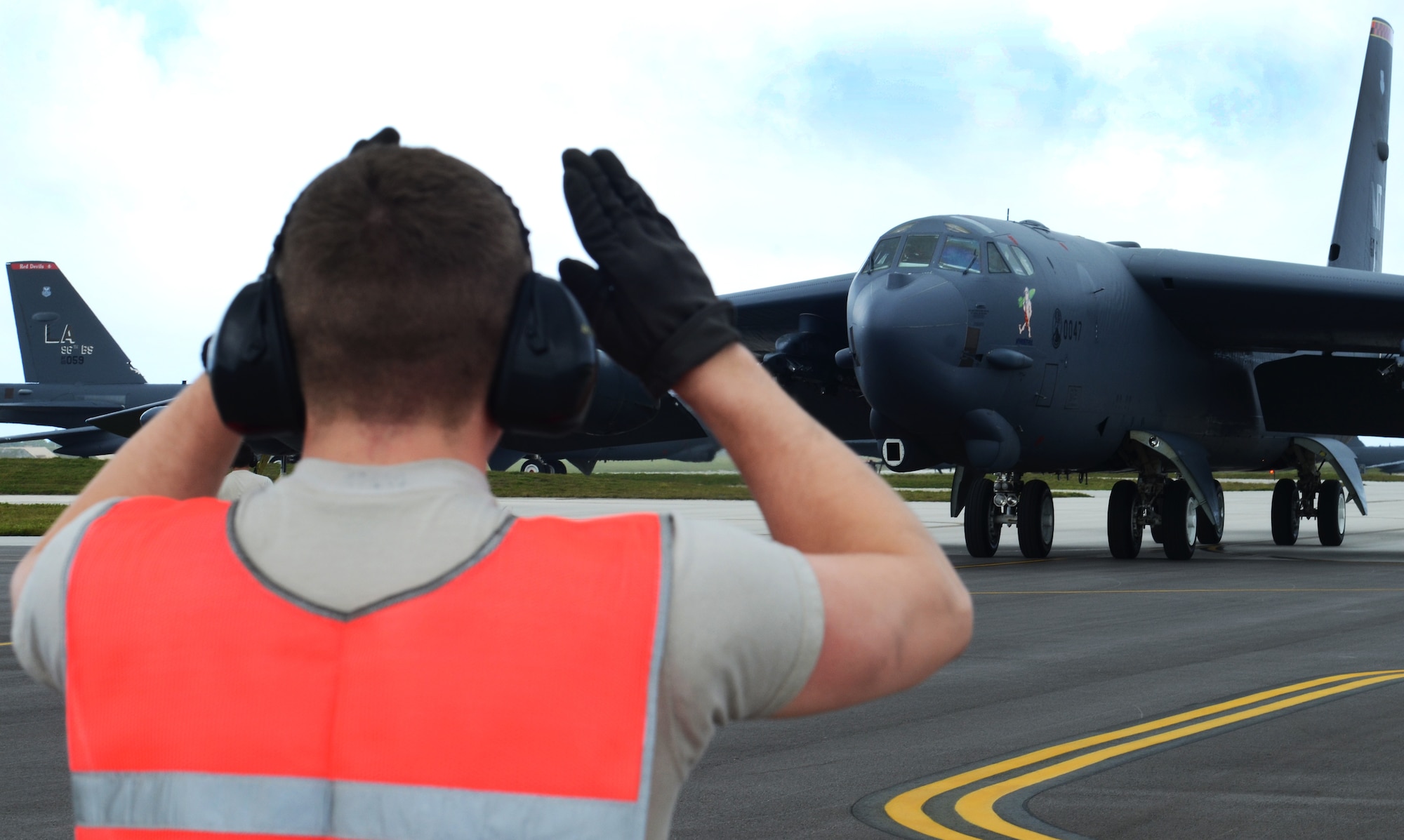 Airman 1st Class Kevin Carmel, 36th Expeditionary Aircraft Maintenance Squadron crew chief, deployed from Minot Air Force Base, N.D., guides a B-52 Stratofortress to its parking ramp at Andersen Air Force Base, Guam, April 2, 2013. A new rotation of aircrews, maintenance personnel and aircraft arrived to Guam March 31 to replace the 96th Expeditionary Bomb Squadron in support of U.S. Pacific Command’s continuous bomber presence mission.  (U.S. Air Force photo by Senior Airman Benjamin Wiseman/Released)