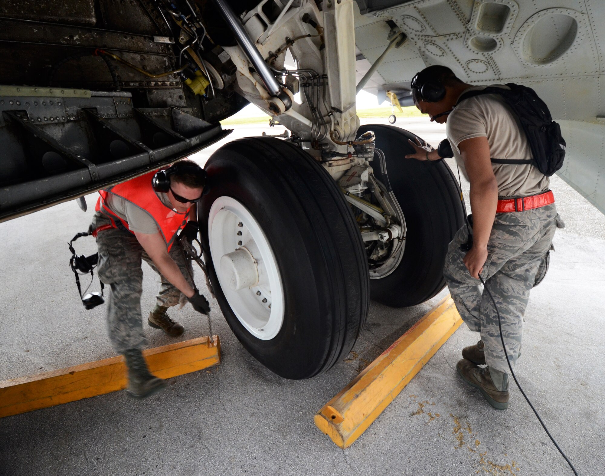 Airmen 1st Class Kevin Carmel (Left), and Julius Smith, 36th Expeditionary Aircraft Maintenance Squadron crew chiefs deployed from Minot Air Force Base, N.D., remove chalks from the tires of a B-52 Stratofortress during a preflight check at Andersen Air Force Base, Guam, April 2, 2013. A new rotation of aircrews, maintenance personnel and aircraft arrived to Guam March 31 to replace the 96th Expeditionary Bomb Squadron in support of U.S. Pacific Command’s continuous bomber presence mission. (U.S. Air Force photo by Senior Airman Benjamin Wiseman/Released)