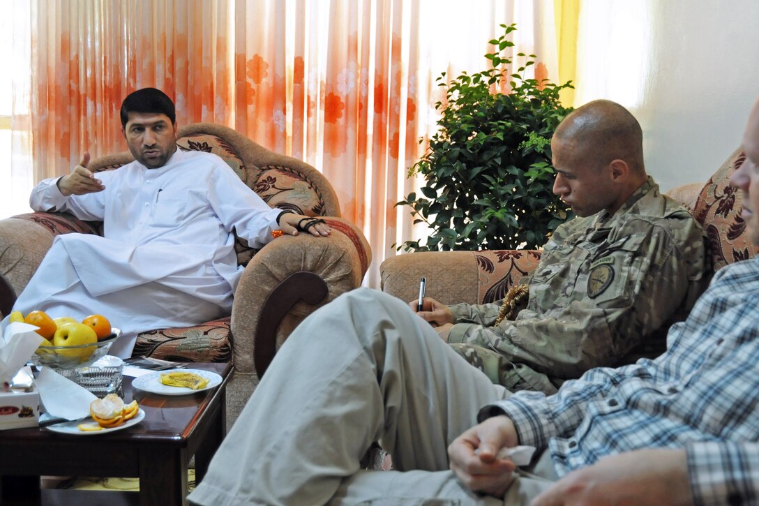 Mohammed Akram Khpalwak, left, Farah provincial governor, speaks with U.S. Navy Cmdr. Louis McCray, center, and Ray Sudweeks, right, U.S. State Department representative with Provincial Reconstruction Team Farah, during a meeting at the governor's compound in Farah City, Afghanistan, April 1, 2013. McCray is commanding officer of Provincial Reconstruction Team Farah.