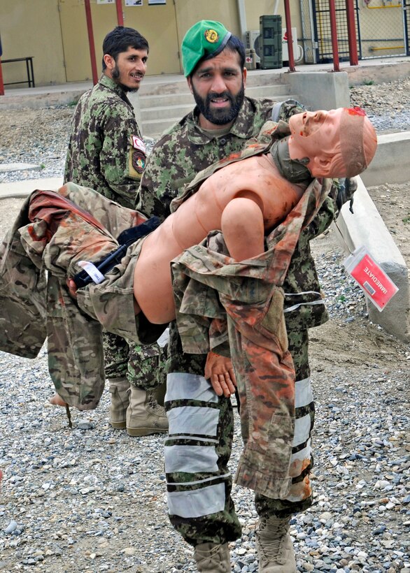 An Afghan army medic moves a practice dummy mannequin to a safer location for tactical field care and further medical treatment during the care-under-fire phase of a combat life saver class on Forward Operating Base Gamberi in Laghman province, Afghanistan, March 27, 2013.