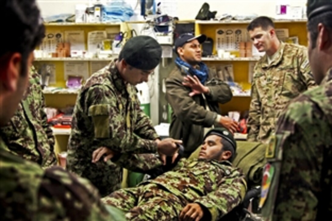 U.S. Army Capt. Seth Enterline, second from right, observes as an Afghan soldier teaches fellow combat medics how to apply a tourniquet to an upper extremity during medical training on Forward Operating Base Joyce in Afghanistan's Kunar province, March 18, 2013. Enterline is assigned to the 2nd Brigade, 201st Corps Security Force Advisory and Assistance Team.