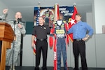National Guard NASCAR driver Casey Mears (center) and new driver Landon Cassill display a racing suit presented to the Army National Guard's Readiness Center during a Sept. 6 visit to the Arlington, Va., facility. Col. Michael Jones, chief of the National Guard Bureau's Recruiting and Retention Division, introduced the drivers to the Soldiers who later lined up for autographs.