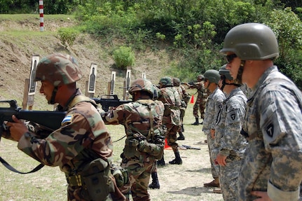 Members of the Honduran rapid response team (left), known as the Peacekeeping Operations Battalion, shot more ammunition in two days than they usually fire all year during their coalition training with 36th Infantry Division Soldiers Sept. 11-13.