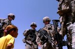 Soldiers from Company A, 1st Battalion, 149th Infantry Regiment, joke with a local Iraqi girl while on patrol in the Al Furat section of Baghdad, Thursday, Aug. 29, 2007. Soldiers from the unit have been working with local officials to assist with rebuilding schools and other facilities in the area.