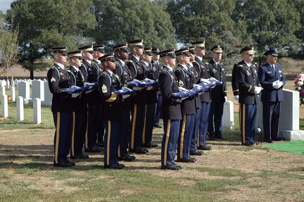 Army honor guard Soldiers hold 12 folded American flags during an interment ceremony at Arlington National Cemetery Oct. 10 for 12 Soldiers killed in Iraq 10 months ago. The Soldiers, 10 from the Army National Guard and two from the active duty Army, were killed northeast of Baghdad when their UH-60 Black Hawk helicopter was shot down.