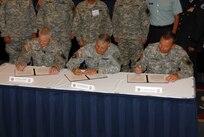 Director of Army National Guard Lt. Gen. Clyde Vaughn, Army Vice Chief of Staff Gen. Richard Cody and Lousiana Adjutant General and Chairman of the Adjutants General Association of the United States Force Structure Committee Maj. Gen. Bennett Landreneau sign a memorandum of understanding to formalize the Army plan to rebalance. The signing ceremony took place at the annual Association of the U.S. Army's annual conference in Washington.