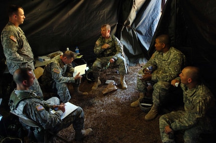 U.S. Army Lt. Col. James Mosteller, center, commander of 1st Battlion, 113th Field Artillery Regiment, listens during a commanders meeting during annual training at Camp Shelby, Miss., April 19, 2007. Mosteller is in the North Carolina Army National Guard, and is 1 of approximately 1,800 soldiers from the 30th Heavy Brigade Combat Team who held their annual training at Camp Shelby. The 30th was one of seven National Guard brigades alerted by the Department of Defense Oct. 19 to serve as replacement forces for Operation Iraqi Freedom. The first of these brigades will not deploy until summer, and many will not deploy until late 2008 or 2009, said Pentagon spokesman Bryan Whitman.