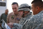 Lt. Col. Keith Lochner, in the middle, the deputy commander for the Task Force San Diego and the 40th Infantry Brigade Combat Team executive officer, reviewed the flight plan on a map with Sgt. Phillip Ziegler, a crew chief with Company B, 1st Battalion, 140th Aviation (Air Assault), just prior to lifting off Thursday morning.