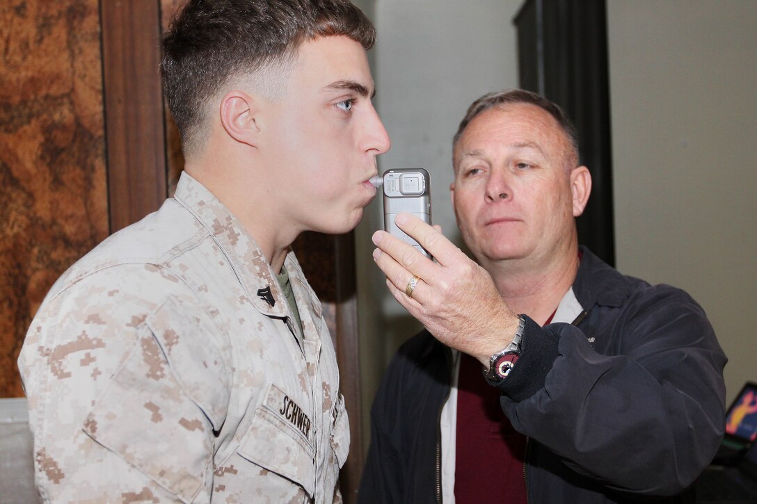 Cpl. Will Schwer, left, and Jerry Cole gave an exhibition on how the Alcomate Premium breath alcohol testers should be used when administering alcohol screenings. Cole is a substance abuse program specialist here and Schwer is a laboratory technician with Marine Light Attack Helicopter Squadron 469.