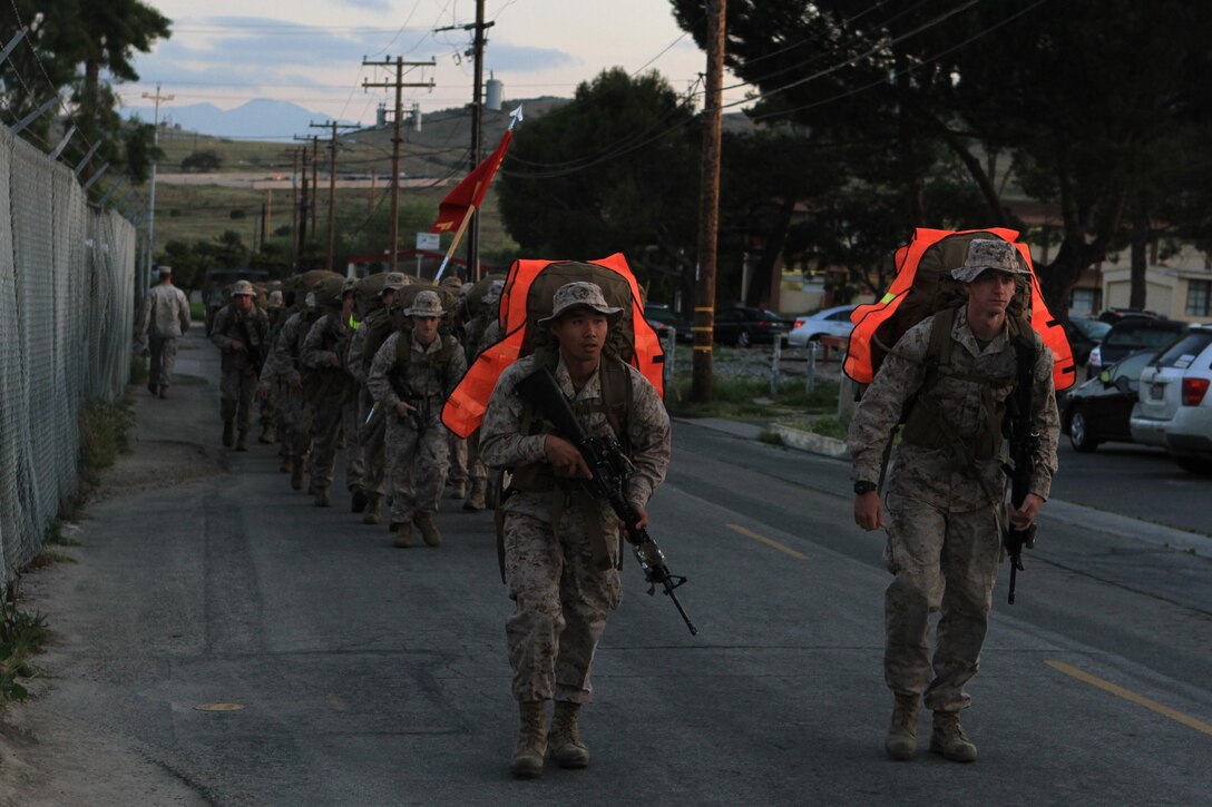 Marines serving with Fox Company, 2nd Battalion, 1st Marine Regiment, hike an 11-mile route with a full combat load to their next training destination here, April 2, 2013. The hike started at 6:30 a.m. and finished approximately four hours later. The company conducts hikes weekly to build strength, confidence and unit-readiness. The hikes also give small-unit leaders an opportunity to lead Marines and build camaraderie.