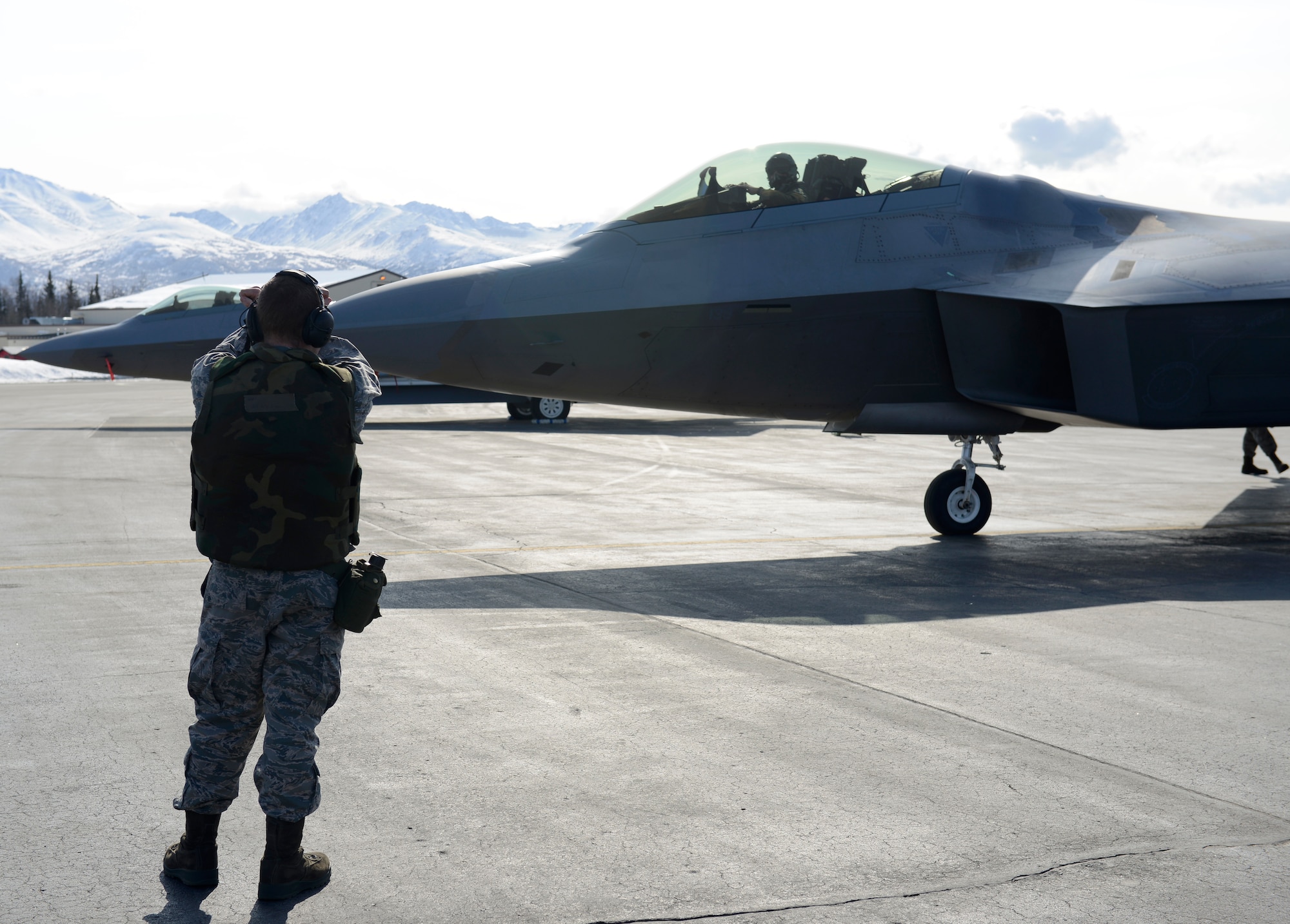 An Airman taxis in an F-22 after arriving during Polar Force 13-3 Exercise on Joint Base Elmendorf-Richardson April 3. The exercise is designed to validate the wings' ability to integrate, mobilize, and prepare assigned personnel, aircraft and equipment for their wartime mission and to employ forces and weapons systems to perform tasked missions. (U.S. Air Force photo/ Airman 1st Class Tammie J. Ramsouer)