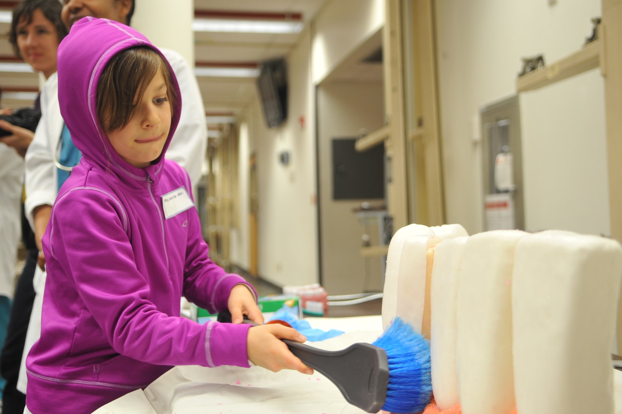 Emily Schlak, 8, brushes plaque away from a mock dental display during the Home School Dental Program at the hospital on Osan Air Base, Republic of Korea, April 2, 2013. The Home School Dental Program, an information and education class aimed at promoting dental health, encouraged participants to take part in hands-on activities in an effort to better understand the importance of dental hygiene. (U.S. Air Force photo/Tech. Sgt. Raymond Mills) 