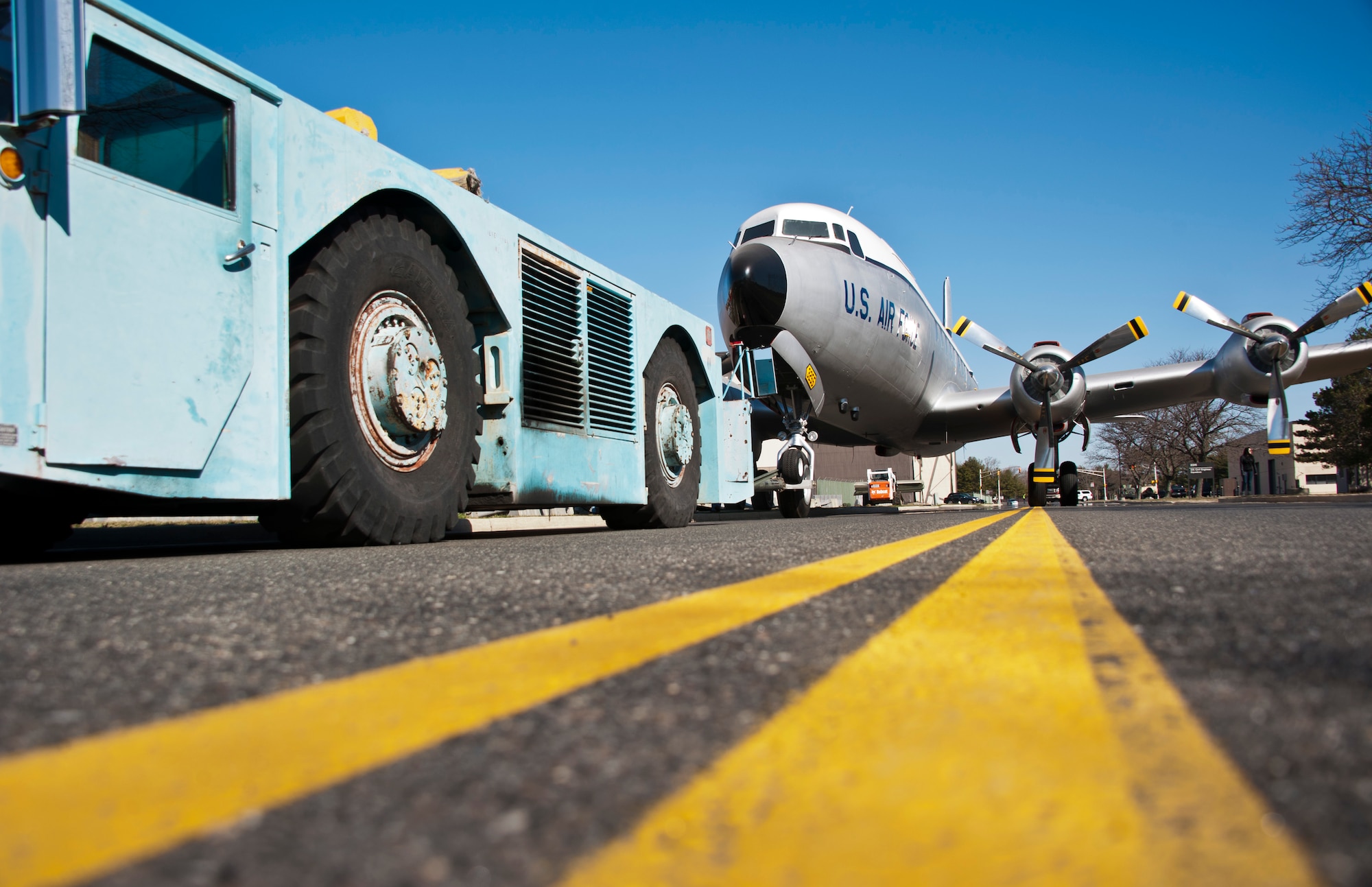 A C-118 Liftmaster is towed down West Arnold Avenue to its static display location in front of the McGuire Passenger Terminal on Joint Base McGuire-Dix-Lakehurst, N.J., March 30, 2013. The historic C-118 was the first cargo plane assigned to then McGuire Air Force Base in 1954. This Liftmaster, as well as many other C-118s, contributed to operations SAVE HAVEN I and II, saving more than 14,000 Hungarian refugees from communist oppression from 1956-1957. (U.S. Air Force photo by Staff Sgt. David Carbajal/Released)