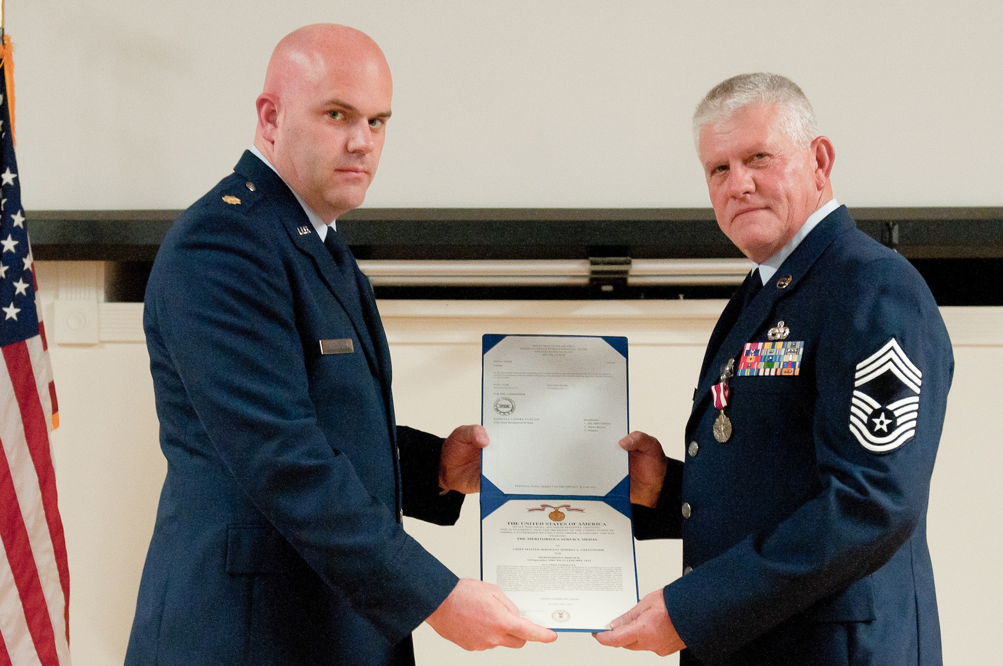 Chief Master Sgt. Jeffrey L. Greenwood (right) is presented with a Meritorious Service Medal by Maj. Kevin E. Thornberry, commander of the 123rd Logistics Readiness Squadron, during a retirement ceremony held in Greenwood’s honor at the Kentucky Air National Guard Base in Louisville, Ky., on Jan. 13, 2013. Greenwood, the 123rd Airlift Wing's vehicle fleet manager, served in the active-duty Air Force and Air National Guard for 32 years. (U.S. Air Force photo illustration by Airman Joshua Horton)