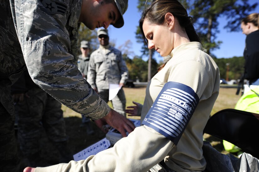 Senior Airman Andrew Szoke, 628th Civil Engineer Squadron firefighter, checks Staff Sgt. Jessica McFelia’s 628th Medical Group bioenvironmental engineer craftsman, vital signs before donning a Level A HAZMAT suit March 28, 2013, at Joint Base Charleston-Air Base, S.C. Szoke checked every Airmen's blood pressure, heart rate and basic vital signs before and after the Airmen donned the suits as an extra precaution ensuring their safety. (U.S. Air Force photo by Staff Sgt. Rasheen Douglas)