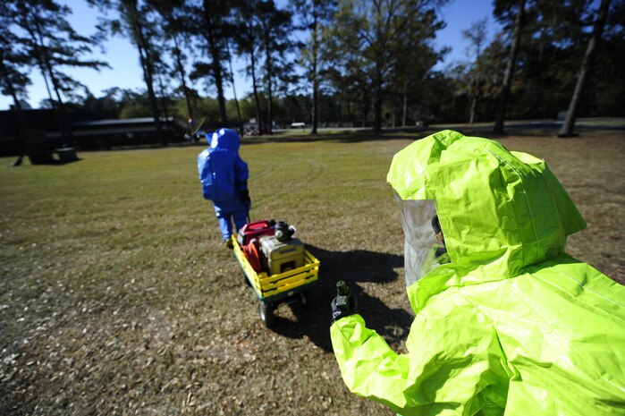 Staff Sgt. Jessica McFelia, 628th Medical Group bioenvironmental engineer craftsman, assists Senior Airman Nicole Browning, 628th Civil Engineer Squadron emergency management journeyman, as they simulate clearing an area that might have been exposed to radiation during an exercise March 28, 2013, at Joint Base Charleston - Air Base, S.C. The 628th MDG Bioenvironmental Flight trains with the 628th CE Emergency Management Flight to refine their emergency response skills and to improve their preparedness and response initiatives. (U.S. Air Force photo by Staff Sgt. Rasheen Douglas)