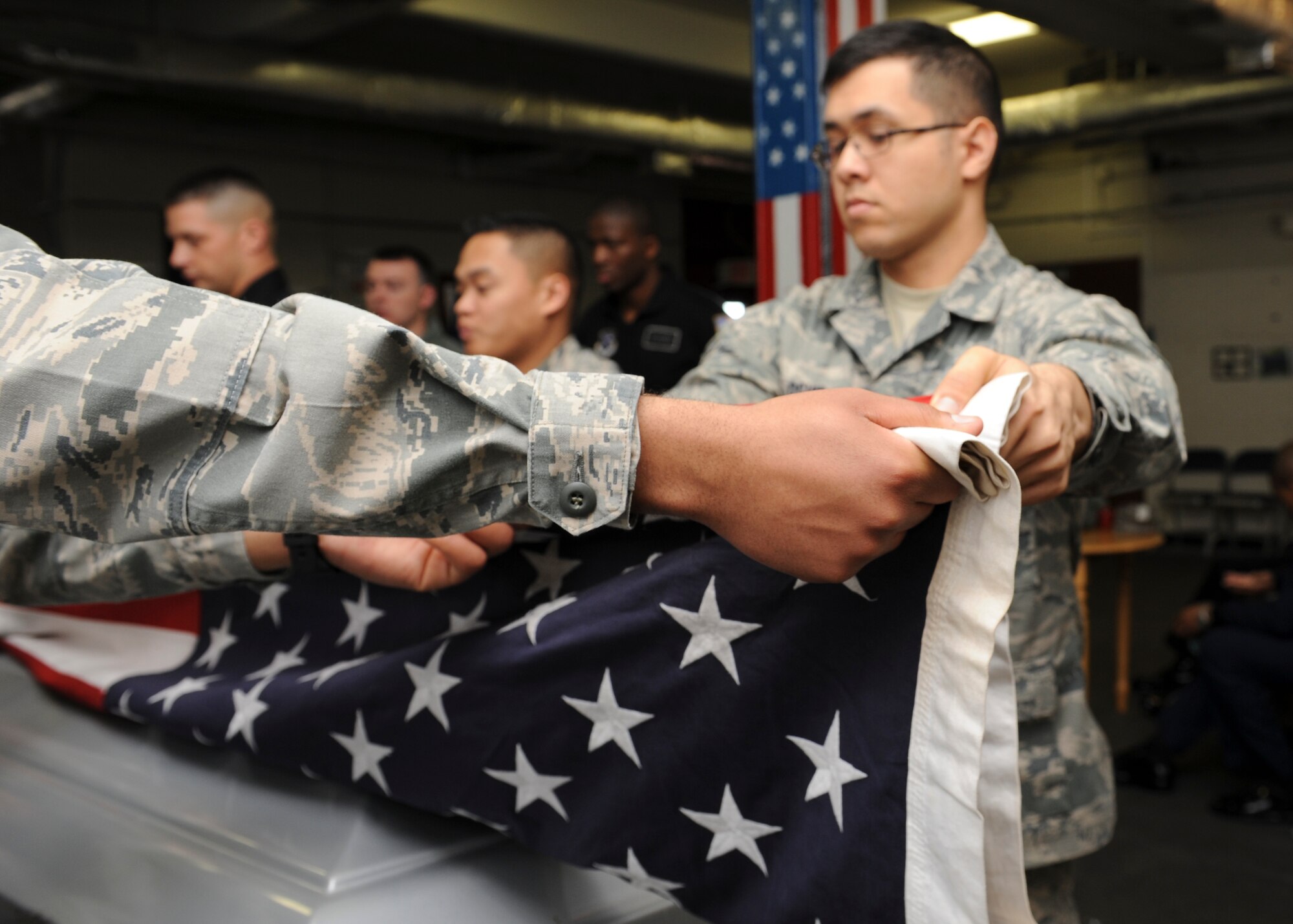 Airmen from the Langley Air Force base honor guard fold the ceremonial flag in front of the U.S. Air Force Honor Guard Drill Team during a recruitment visit to Langley Air Force Base, Va., March 29, 2013.  The Drill Team promotes the mission by showcasing drill performances at public and military venues to recruit, retain and inspire. (U.S. Air Force photo by Airman 1st Class Kimberly Nagle/Released)
