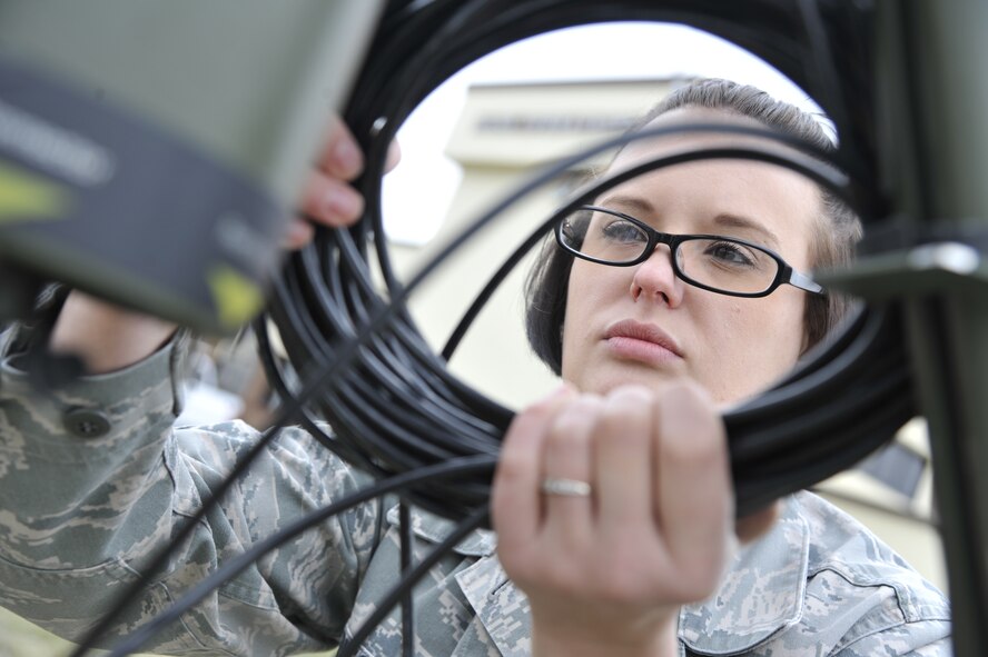 U.S. Air Force Senior Airman Heather Rieck, 509th Operation Support Squadron weather journeyman,un-rolls a power cord for the TMQ-53, Whiteman Air Force Base, Mo., March 20, 2013. The cord hooks up to different pieces of the central unit so that all information collected by different sensors can be compiled into one observation. The TMQ-53 is a machine measures wind speed, temperature, precipitation, wind direction and pressure (U.S. Air Force photo by Airman 1st Class Keenan Berry/Released)  
